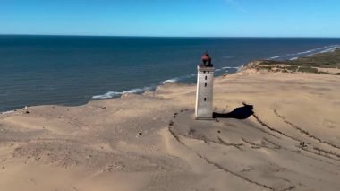 Danimarka sahillerinde bulunan çarpıcı Rubjerg Knude deniz fenerini deneyin. Bu tarihi yapı uçsuz bucaksız kumullara ve Kuzey Denizi 'ne tepeden bakıyor. Nefes kesici doğal güzellikler sergiliyor..
