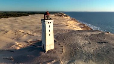 Rubjerknudde Deniz Feneri 'nin kumlu kum tepelerinin ve Kuzey Denizi' nin zeminine dik duran nefes kesici manzarasını deneyin. Kıyı ve mimari fotoğrafçıları için ideal..