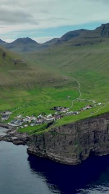 Faroe Adaları 'nın sakin köyü Gjogv' u keşfedin. Etrafı dramatik uçurumlar ve yemyeşil tepelerle çevrili. Barışçıl sahil topluluğu çarpıcı manzaralar ve sakin bir atmosfer sunuyor..