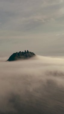 Bulutlar, sakin bir günbatımında Faroe Adaları 'ndaki ikonik Drangarnir tepelerini kaplar. Dramatik manzara büyüleyici bir manzara yaratır. Bu uzak istikamette güzelliği yakalar..