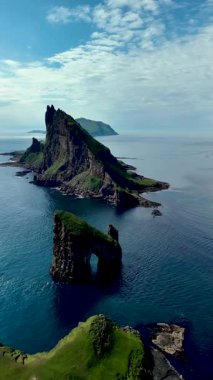 Drangarnir 'in dramatik uçurumları, göz kamaştırıcı Faroe Adaları' ndaki derin mavi sularla çevrili berrak bir gökyüzüne karşı dik dururlar. Güzellik ve huzurun mükemmel bir kombinasyonu..