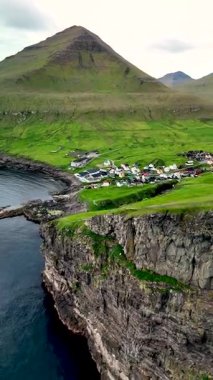 Faroe Adaları 'ndaki yüksek uçurumların kenarına tünemiş Gjogv köyünü keşfetmek, canlı evler ve doğal güzellikler sergilemek. Bu sakin yer nefes kesici kıyı manzarası sunuyor..
