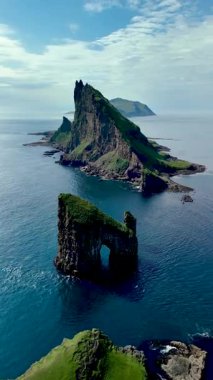 Faroe Adaları 'ndaki Drangarnir' in çarpıcı güzelliğini keşfedin. Uçsuz bucaksız gökyüzünün altındaki derin mavi sulardan yükselen dramatik uçurumlar..