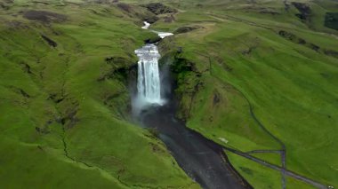 Skogafoss şelalesi, canlı yeşil tepelerle çevrili yüksek uçurumlardan gök gürültüsü gibi iniyor. Bu nefes kesici manzara İzlanda 'nın doğal güzelliğini yansıtıyor, doğa meraklıları için mükemmel..