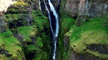 İzlanda 'nın en yüksek kayalıklarından biri olan, nefes kesen Glymur şelalesini keşfedin. Sarp kayalıkların arasından akan canlı yeşil yosunlar ve çarpıcı doğal güzellikler..