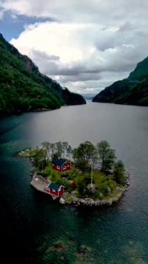Norveç 'teki Lovrafjorden' in göz kamaştırıcı güzelliğini deneyimleyin, sakin suları ve yemyeşil yeşilliklerle çevrili güzel kırmızı bir adaya sahip. Doğa aşıkları ve gezginleri için ideal..