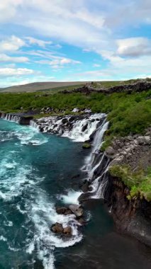 Hraunfossar şelaleleri, yemyeşil ve engebeli uçurumlarla çevrili turkuaz sulara güzelce dökülüyor. İzlanda 'nın benzersiz doğal güzelliklerini sergiliyorlar..