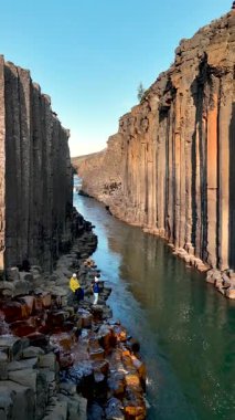 İzlanda 'daki Studlagil Kanyonu' nun nefes kesici güzelliğini keşfedin. Görkemli bazalt sütunlar sakin bir nehrin üzerinde, maceraperestleri ve doğa aşıklarını bu doğal mucizeye şahit olmaya davet ediyor..