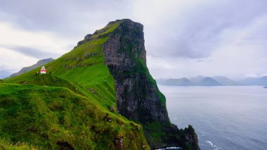 Kallur deniz fenerinin Kalsoy adasındaki kayalıklardaki güzel manzarası. Faroe Adaları, Danimarka Krallığı, Kuzey Avrupa