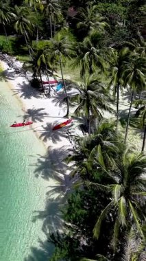Koh Chang, Tayland 'daki Ko Ngam Sahili' nin el değmemiş sahillerinde rahatlayın. Turkuaz suların üzerinde sallanan gür palmiye ağaçları, ziyaretçileri bu tropik cennette güneşlenmeye ve kanoya binmeye davet ediyor..
