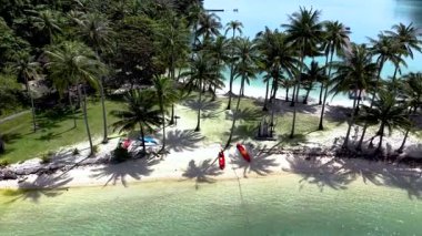 Tayland 'ın Koh Chang kentindeki Ko Ngam Sahili' nin sakin manzaralarını keşfedin. Palmiye ağaçları, berrak sular ve renkli kanolar. Tayland 'da rahatlama ve keşif için mükemmel bir kaçış yolu.