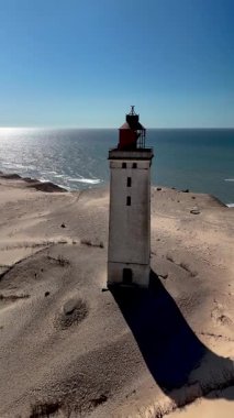 Rubjerg Knude Deniz Feneri, Kuzey Denizi 'nin zeminine karşı heybetli bir şekilde ayakta duruyor. Etrafı kum tepeleriyle çevrili. Bu ikonik yapı Danimarka 'nın deniz tarihi ve doğal güzelliğini gözler önüne seriyor.