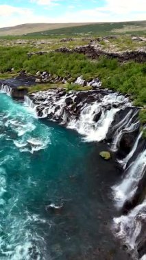 Soluk kesici Hraunfossar Şelalesi 'ni deneyin, suyun aşağıdaki türkuaz nehre doğru eşsiz lav oluşumları üzerine aktığı yeri. Yeşilliklerle çevrili bu İzlanda mücevheri herkesi büyülüyor..