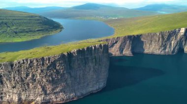 Deniz seviyesinden yüksek olan Sorvagsvatn Gölü 'nün dramatik manzarasını keşfedin. Büyüleyici uçurumlar derin mavi sulara dalıp Faroe Adaları 'nda büyüleyici bir doğa harikası yaratırlar..