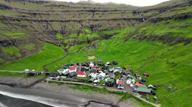 Dik yeşil tepeler ve Faroe Adaları 'nda çarpıcı bir kıyı şeridi ile çevrili büyüleyici bir sahil köyü keşfedin. Tjornuvik Köyü
