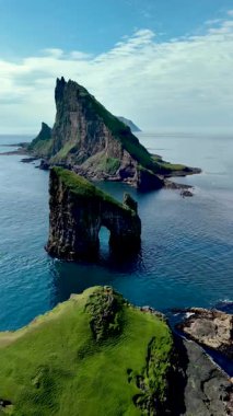 Faroe Adaları 'nın ikonik simgeleri olan muhteşem Drangarnir kaya oluşumlarını araştırın. Görkemli uçurumlar sakin denizin üzerinde, yemyeşil ve uzak ufuklarla çevrili..