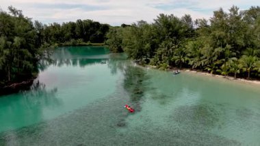 Tayland 'daki Koh Kood Adası' nın nefes kesici manzaralarını keşfedin. Huzurlu turkuaz sular ve yemyeşil alanlar. Kayakçılar canlı göllerde dolaşır, doğal huzuru kucaklarlar.