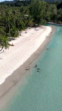 Yumuşak beyaz kumları ve berrak turkuaz sularıyla Koh Kood Adası 'nın güzelliğini yakala. Ziyaretçiler dinlenmeyi ve yüzmeyi severler. Palmiye ağaçları, sakin bir arka planda hafif bir esintide sallanırken..