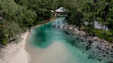 Tayland 'daki Koh Kood Adası' nın güzelliğini keşfedin. Rüzgarda sallanan palmiye ağaçları gibi yumuşak dalgalar kıyıya vurur ve huzurlu bir tropikal cennet yaratır..