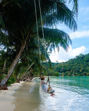 Koh Kood Adası 'nda, bir kadının bereketli palmiye ağaçlarıyla çevrili bir sahilde sallanmaktan hoşlandığı huzurlu bir manzara gözler önüne seriliyor. Turkuaz sular Tayland 'da rahatlamaya ve sükunete davetiye çıkarır.