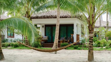 Palmiye ağaçlarıyla çevrili sıcak bir bungalovla Koh Kood Adası 'nın huzurlu atmosferinin tadını çıkarın. Tayland 'ın yumuşak kumlu sahillerinde gevşemek ve tropikal mutluluk için mükemmel bir dinlenme yeri.
