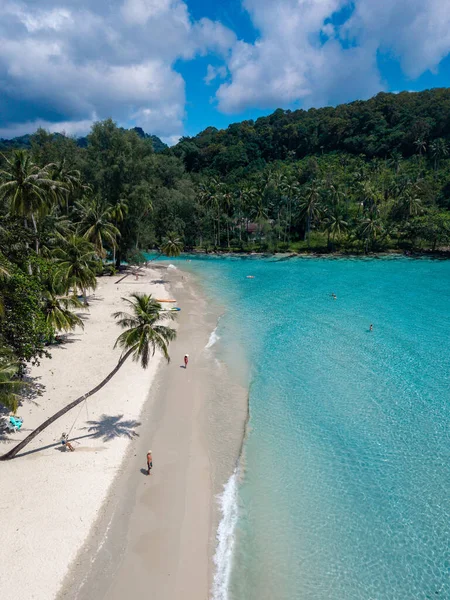 Tayland 'daki Koh Kood Adası' nın huzurlu güzelliğini tecrübe edin. Yumuşak kumlu sahil berrak mavi gökyüzünün altında canlı turkuaz sularla buluşuyor. Bereketli palmiye ağaçları tropik cennet atmosferini güçlendirir..