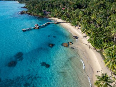 Koh Kood Adası, masmavi suların ve beyaz kumlu plajların nefes kesici manzarasını sunuyor. Kıyı boyunca uzanan yemyeşil palmiye ağaçları rahatlama ve keşif için ideal bir tropikal cennet yaratıyor..