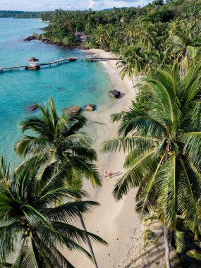 Tayland 'daki Koh Kood Adası' nın el değmemiş güzelliğini keşfedin. Muhteşem plajlar, sallanan palmiye ağaçları ve sakin turkuaz suları. Güneş doğarken sahilde huzurlu bir gezintinin tadını çıkar..