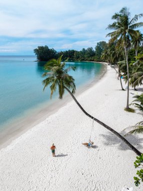 Altın kumlar, Tayland 'daki Koh Kood Adası' nda kristal berraklığında sularla buluşur. Palmiye ağaçları, ziyaretçiler gibi, sakin sahil atmosferinin tadını çıkarırken nazikçe sallanıyor. Rahatlamak ve doğaya gömülmek için mükemmel..