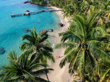 Tayland 'daki Koh Kood Adası' nın el değmemiş kumlu plajı boyunca birkaç gezinti. Palmiye ağaçları berrak turkuaz suları çerçeveletip rahatlamak için mükemmel bir tropikal kaçış ortamı yaratıyor..