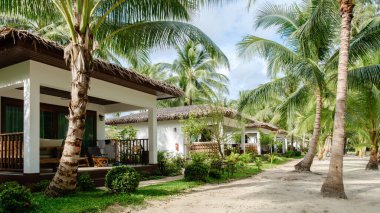 Tayland 'daki Koh Kood Adası' nın dingin güzelliğini tecrübe edin. Sahile bakan büyüleyici bungalovlar, bereketli palmiye ağaçları ve yumuşak kumlu yollar ile çevrilidir. Rahatlatıcı bir kaçış için mükemmeldir..