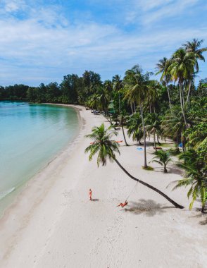 Tayland 'daki Koh Kood Adası çarpıcı kıyı şeritleri, kristal berrak sular ve huzurlu bir ortam sunuyor. Palmiye ağaçları usulca sallanıyor, plajda rahatlama ve eğlence için huzurlu bir ortam yaratıyor..