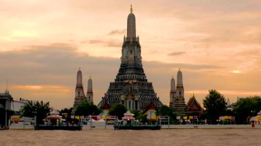 Şafak Tapınağı olarak da bilinen Wat Arun, Bangkok, Tayland 'da nehir kıyısında duruyor. Çarpıcı mimari, günbatımının canlı renklerini yansıtıyor ve güzel bir manzara yaratıyor..