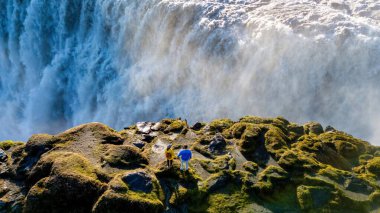 İki maceracı Dettifoss şelalesinin kıyısında durup güçlü şelaleye hayret ediyor..