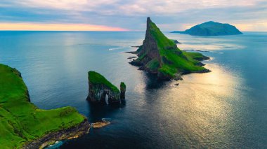 Faroe Adaları 'ndaki Drangarnir Denizi Yığınları. Gün batımında Vagar Adası' ndaki Drangarnir Kayalık Kemerleri. Faroe Adaları.