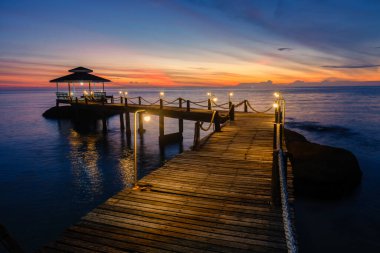 Tayland 'da gün batımında Koh Kood Adası' nın sakin sularına huzurlu bir ahşap iskele uzanır.