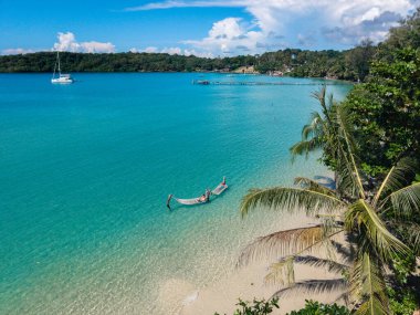 Temiz turkuaz sular Koh Kood Adası 'nda yumuşak kumlu kıyılarla buluşur. Tayland 'ın mavi okyanusunda bir çift hamakta dinleniyor.