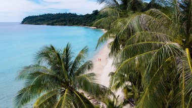 Koh Kood Adası 'nın nefes kesici turkuaz suları ve yumuşak kumlu plajlarıyla sakin güzelliğini keşfedin. Uzun palmiye ağaçları sıcak tropikal güneşin altında yavaşça sallanır, Tayland 'da rahatlamak için mükemmeldir.