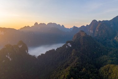Khao Sok Ulusal Parkı 'nın üzerindeki büyüleyici bir gündoğumu görkemli dağları ve Tayland' ın sık ormanlarını gözler önüne seriyor.