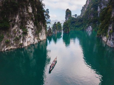 Khao Sok, Tayland 'daki Cheow Lan Gölü' nün huzur veren güzelliğini keşfedin. Turistli geleneksel bir uzun kuyruklu tekne.