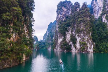 Çamurlu kireçtaşı kayalıklarının çerçevelediği Cheow Lan Gölü 'nün turkuaz sularında süzülen küçük bir tekne gibi sakin bir manzara gözler önüne seriliyor. Khao Sok Tayland