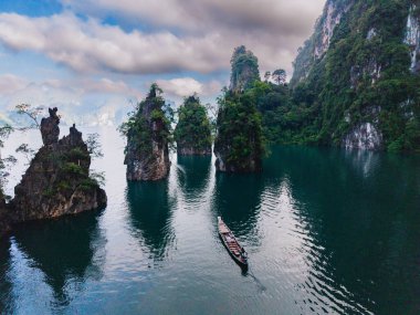 Khao Sok Ulusal Parkı Tayland 'daki yüksek kireçtaşı tepeleri ve yemyeşil çimenliklerle çevrili Cheow Lan Gölü' nün sakin sularını deneyin. Bu manzaralı cennette huzurlu bir tekne yolculuğunun tadını çıkar..
