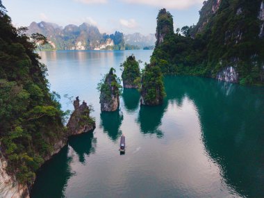 Khao Sok Ulusal Parkı 'na yerleşen Cheow Lan Gölü' nde büyüleyici kireçtaşı karstları ve kristal berrak suları sunuluyor. Küçük bir tekne huzurlu manzarada süzülür, el değmemiş doğasını gösterir..