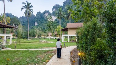 Tayland 'ın Khao Sok kentindeki sakin yollarda dolaşın. Çevreleriniz göz kamaştırıcı yeşillikler ve lüks bir eko bölgesindeki eşsiz kaya oluşumlarıyla çevrili.