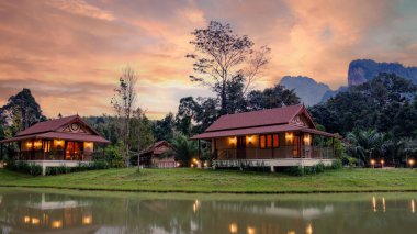 Geleneksel pansiyonların huzurlu bir göl kenarında zarafetle oturduğu Tayland, Khao Sok 'un dingin güzelliğini keşfedin. Gün batımının yumuşak renkleri rahatlamak için mükemmel, sakin bir zemin oluşturur..