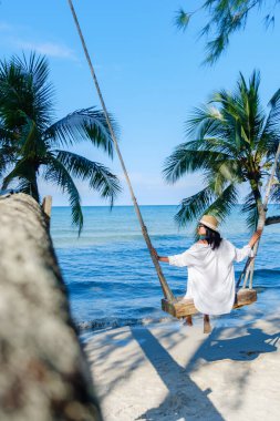 Huzurlu bir an sahilde salıncakta sallanan bir kadını yakalar. Etrafı gür palmiye ağaçlarıyla çevrilidir. Sakin deniz, parlak güneş ışığı altında parıldıyor. Tayland 'a mükemmel bir tropikal kaçış sunuyor.