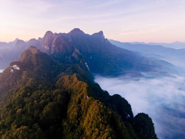 Tayland 'daki Khao Sok Ulusal Parkı' nın nefes kesen manzarasını keşfedin. Bu sakin sahne doğanın şafak vakti güzelliğini yakalar..