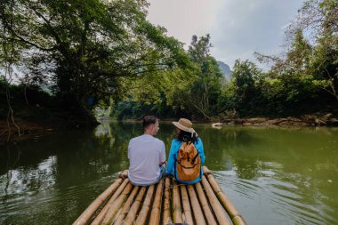 İki gezgin, Khao Sok 'ta huzurlu bir nehirde sakin bir bambu rafting deneyimi yaşıyor. Etrafı canlı yeşillik ve görkemli tepelerle çevrili. Rahatlamak ve macera yaşamak için mükemmel..