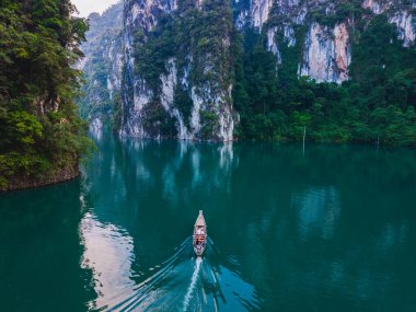 Yüksek kireçtaşı tepeleri ve yemyeşil yeşilliklerle çevrili Cheow Lan Gölü 'nün sakin atmosferini hissedin. Bir tekne zümrüt sularında sorunsuzca süzülür, macera ve rahatlamaya davetiye çıkarır..