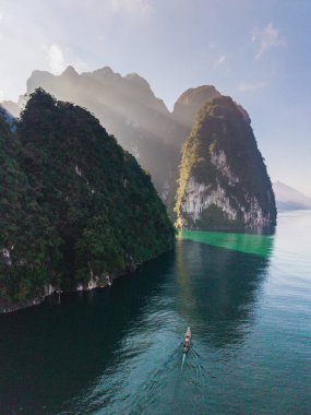 Geleneksel bir tekne zümrüt sularda süzülürken ve yüksek kireçtaşı kayalıklarıyla çevriliyken Cheow Lan Gölü 'nün sakinliğini hissedin. Doğal güzellik Khao Sok Tayland 'daki her ziyaretçiyi cezbeder.